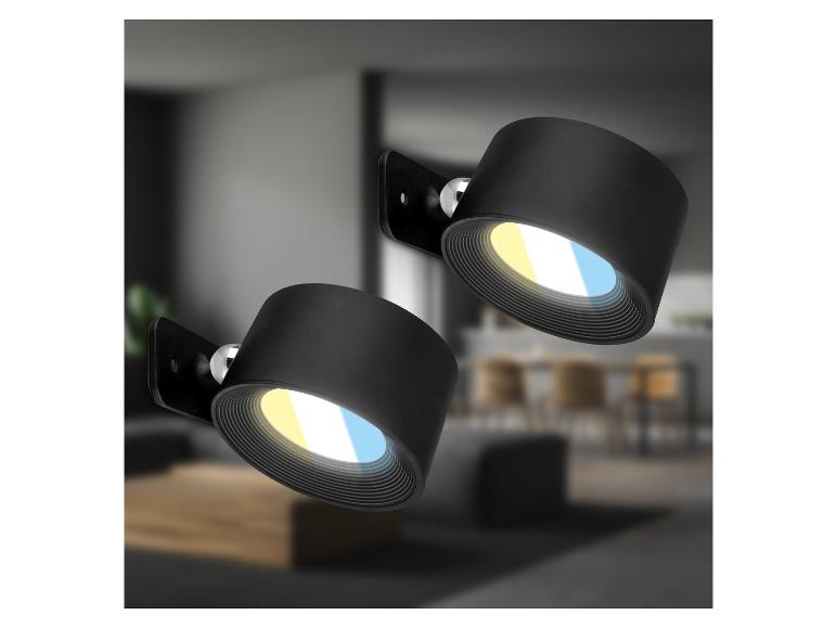 Zwei schwarze Wandstrahler mit warmem und kaltem Licht in modernem Interieur.
