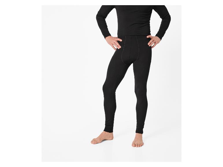 Mann in schwarzen Leggings und Langarmshirt, Hände in die Hüften gestemmt.