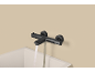 Moderne schwarze Thermostat-Badewannenarmatur mit fließendem Wasser.
