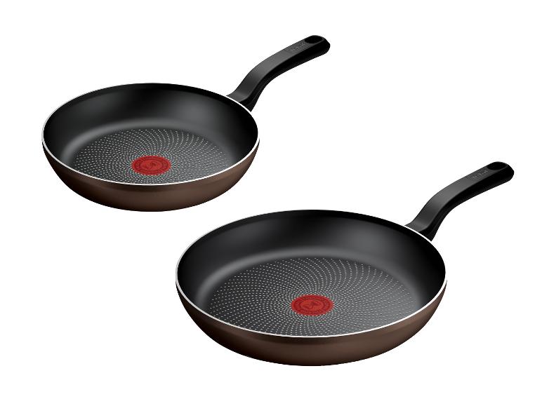 Zwei braune Bratpfannen mit schwarzen Griffen und einem roten Thermo-Spot in der Mitte.