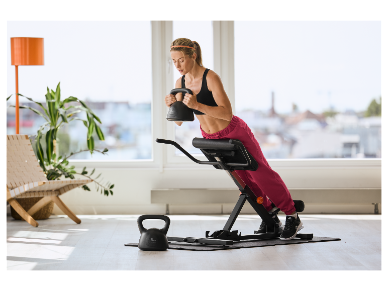Frau trainiert mit CRIVIT 6 kg Kettlebell und Rückentrainer.