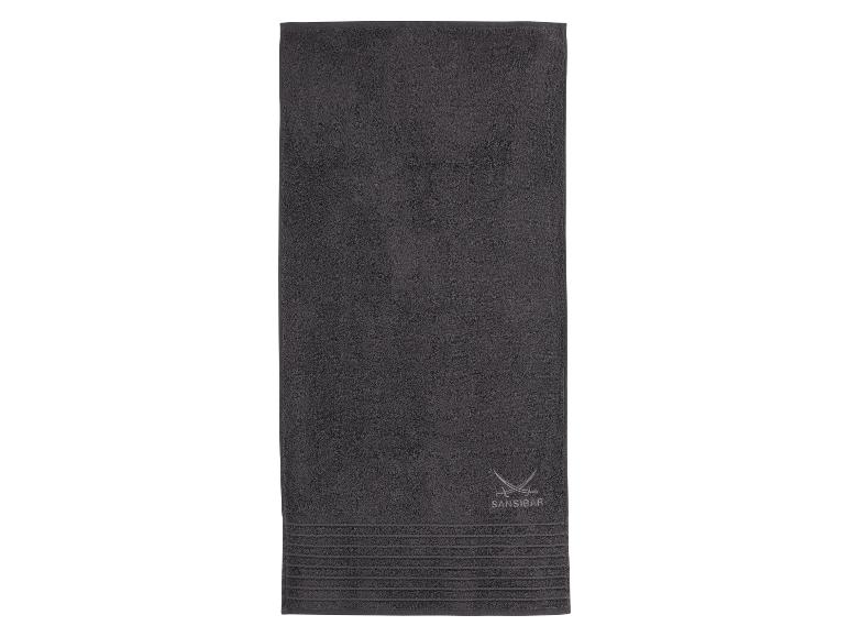 Dunkelgraues Sansibar Handtuch mit gesticktem Logo und Zierstreifen.