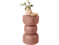 Beige Vase mit Eukalyptus und Schale auf einem rosa dreistufigen Beistelltisch.
