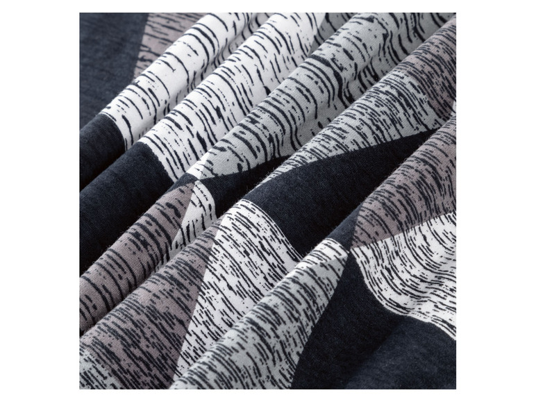 Nahaufnahme eines dunkelblauen Stoffes mit einem weißen und grauen geometrischen Muster.