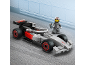 Graues und schwarzes Spielzeug-Rennauto mit Fahrer-Minifigur auf einer Strecke.