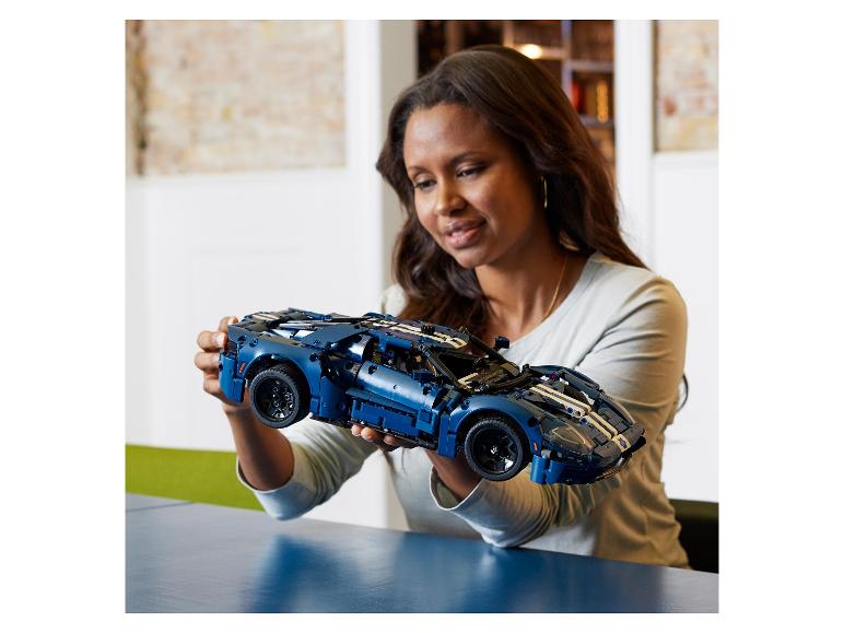 Frau hält ein detailliertes Ford GT Sportwagenmodell aus Bausteinen.