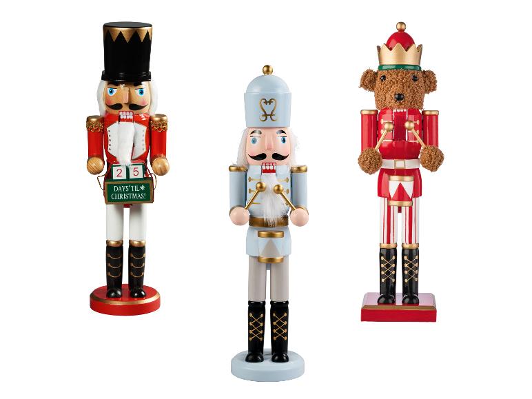 LIVARNO® Nussknacker, 35 cm: Drei festliche Nussknacker, darunter ein Soldat mit Adventskalender und ein Teddybär.