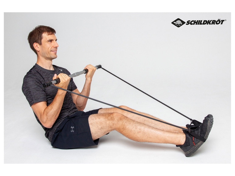 Ein Mann trainiert mit einem Schildkröt Fitness-Gummiband und einer Trainingsstange.