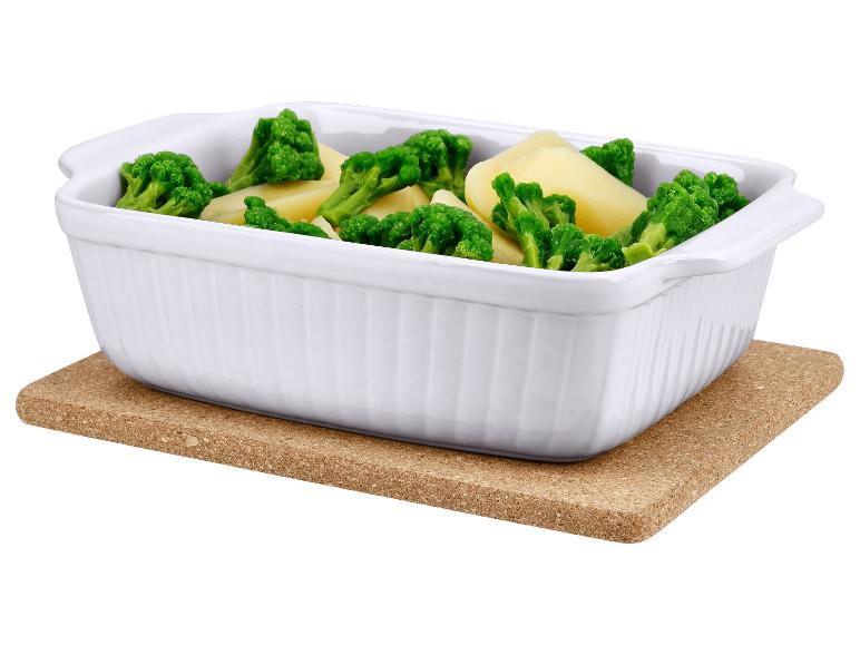 Weiße Keramik-Auflaufform mit Brokkoli und Kartoffeln auf einer Korkunterlage.