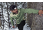 Mann mit Stirnlampe und grüner Jacke im verschneiten Wald.