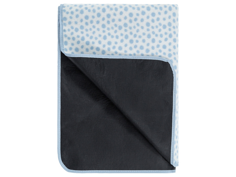 Eine blaue Picknickdecke mit weißen Punkten und wasserfester Unterseite.