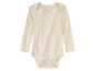 Ein beiger Baby-Strampler mit langen Ärmeln.