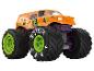 Ein orangefarbener Monstertruck mit großen Reifen und einem Jester-Design.