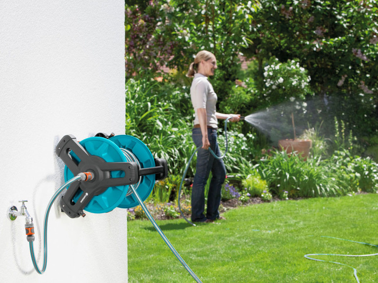 Gardena Gartenschlauchrolle mit Frau, die im Garten gießt.