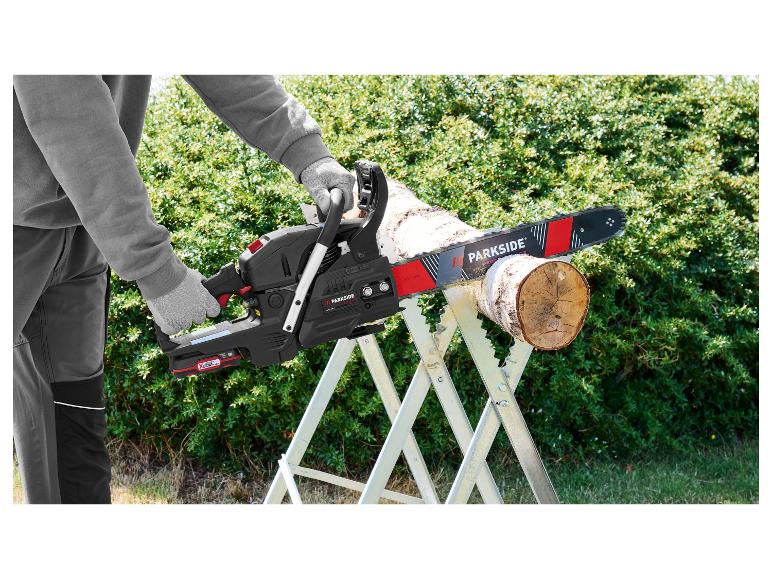 Mann schneidet Holz mit einer Parkside Kettensäge auf einem Sägebock.