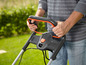Ein Mann benutzt einen Rasenmäher mit einem Griff
