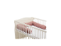 Babybett mit rosa Bettumrandung mit Blumenmuster.