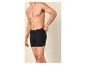 Mann in schwarzen Boxershorts, der den Bund anpasst.