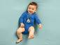 Ein Baby in einem blauen Strampler mit Mickey Mouse