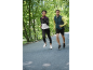 Zwei Läufer in Sportkleidung joggen draußen, Frau in Jacke und Mann in Weste.