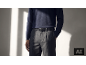 Mann mit dunkelblauem Pullover, grauer Hose und schwarzem Gürtel.