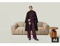 Frau in einem lila Hosenanzug und schwarzem Mantel vor einem Sofa.