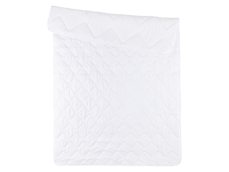 Eine weiße, gesteppte Bettdecke, in der Hälfte gefaltet.