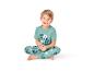 Jungen-Pyjama mit Mickey-Mouse-Print, sitzend und lächelnd.