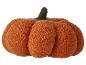 Ein flauschiges orangefarbenes Kürbiskissen.