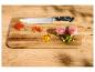 Küchenmesser mit Gewürzen, Fleisch und Gemüse auf einem Holzbrett.