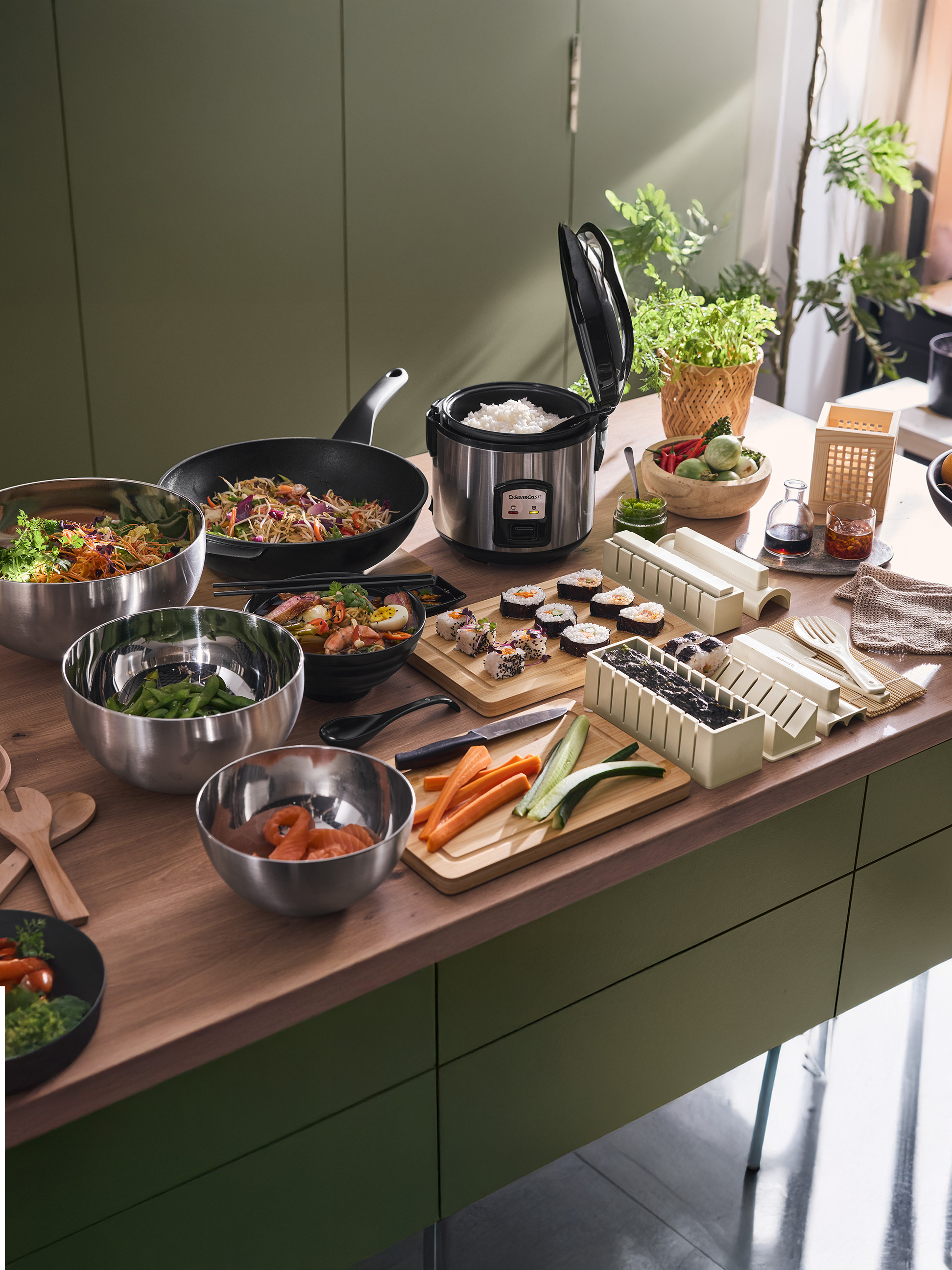 Asiatisches Essen, darunter Sushi, Reis, Nudeln und Gemüse, zubereitet mit Silvercrest-Geräten.