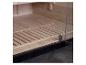 Holzsauna-Interieur mit Glastür und Lattenrostboden.