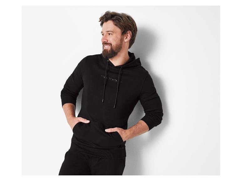 Mann trägt einen schwarzen Kapuzenpullover von New Harbour.