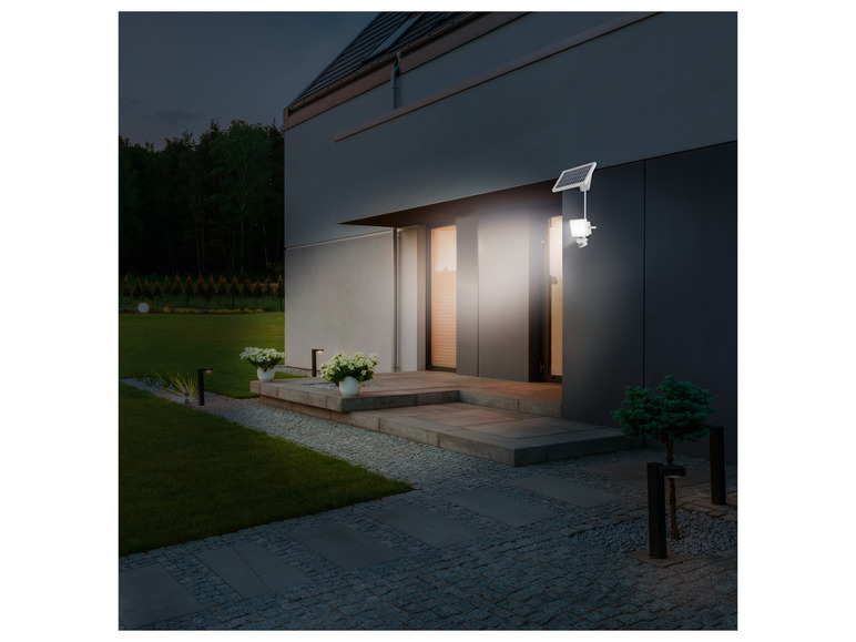 Eine moderne Außenleuchte mit Solarpanel an einem Haus.