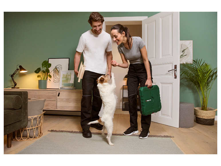 Paar mit Hund zu Hause, Frau hält Parkside Werkzeugkiste.