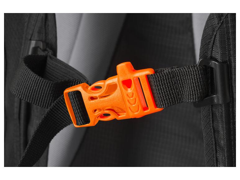 Orangefarbene Schnalle an einem schwarzen Rucksackgurt.