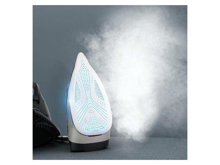 Ein weißes und schwarzes Dampfbügeleisen mit blauen Lichtern, das Dampf vor einem grauen Hintergrund abgibt.