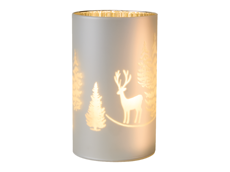Weihnachtsdekorationskerze mit Hirsch und Bäumen, warmes Licht.