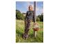 Frau in grauem Pullover und Leopardenhose, die einen Korb Gänseblümchen hält.
