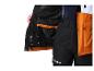 Nahaufnahme einer schwarz-orangen Winterjacke mit schwarzer Hose.