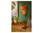 LIVARNO home Herbstdekoration mit LED-Lichtern, Kerzen und bunten Blättern.