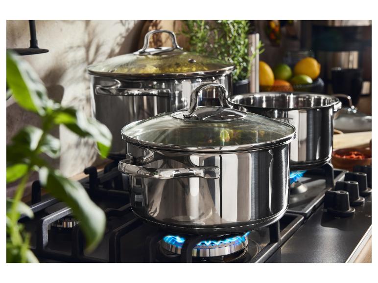 Edelstahltöpfe auf einem Gasherd mit blauen Flammen.