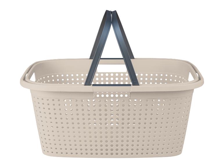 Beige Wäschekorb mit Griffen und Löchern.