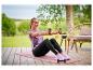 Eine Frau in CRIVIT Damen-Funktionstights beim Workout mit Hanteln auf einer Terrasse