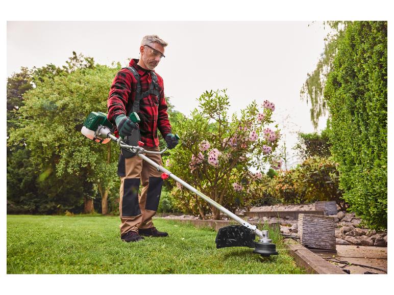 Ein Mann benutzt einen Freischneider, um Unkraut zu entfernen.
