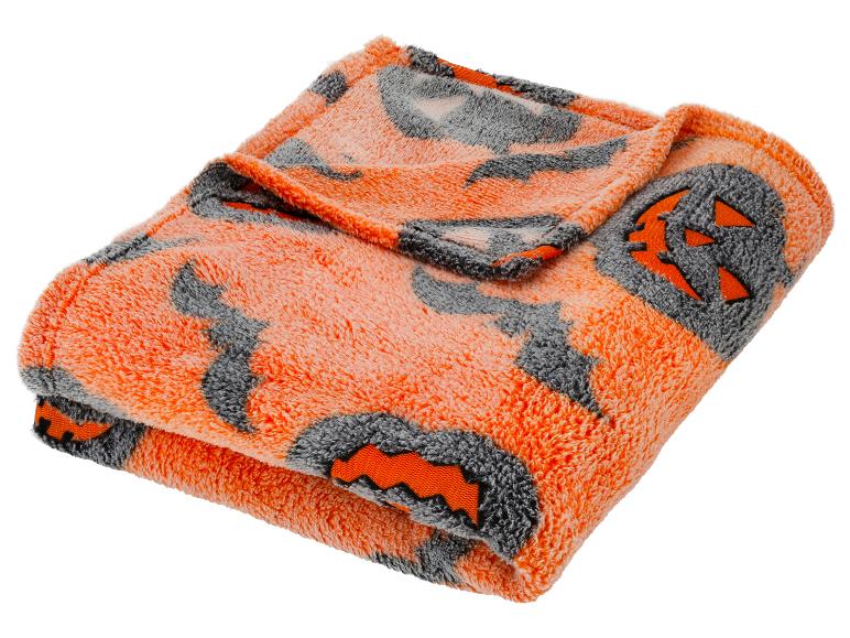 Orange-graue Decke mit Halloween-Kürbismotiven.
