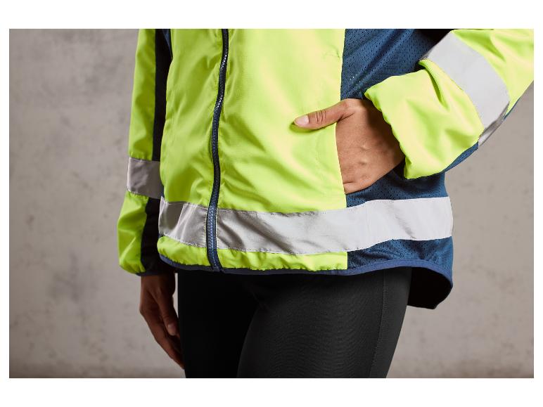 Eine gelbe Windjacke mit reflektierenden Streifen, getragen von einer Person mit schwarzen Leggings.