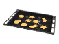 Schwarzes Backblech mit rohen Weihnachtsplätzchen in verschiedenen Formen.