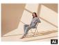 Grauer ESMARA® Damen-Pyjama an einem Model, das auf einem Stuhl sitzt. [KI-generiertes Bild]