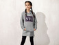 Ein Mädchen trägt einen grauen Hoodie mit NYC-Aufdruck.